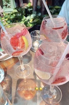 three glasses filled with different types of drinks on top of a table next to each other