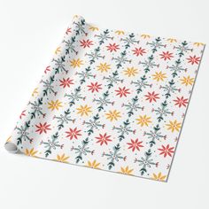 a white wrapping paper with red, yellow and green flowers on it's side