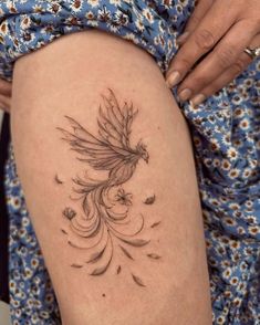 a woman's thigh with a bird tattoo on it