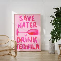 a pink poster that says save water drink tequila next to a chair and potted plant