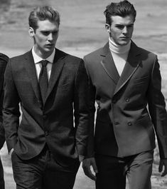 three men in suits walking on the beach