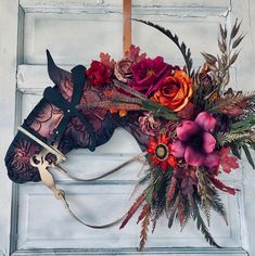 a horse head decorated with flowers and leaves on the front door to a house or business