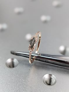 a diamond ring sitting on top of a pair of scissors next to some screws