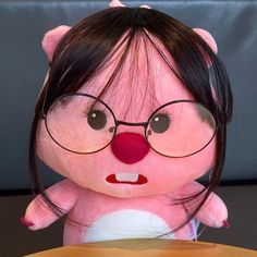 a pink stuffed animal with glasses on it's head