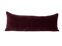 a dark purple velvet pillow on a white background