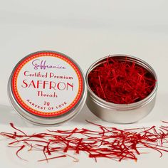 saffron threads in a tin on a white surface