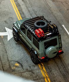 an off - road vehicle is parked on the side of the road with luggage strapped to it's roof