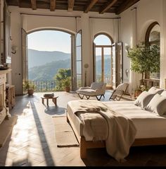 a bedroom with an arched window overlooking the mountains