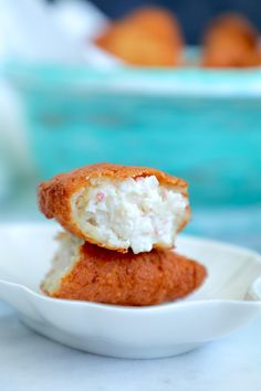 two crab cakes on a white plate with a blue bowl in the backgroud