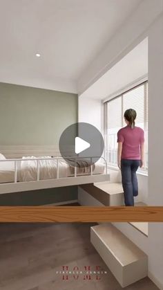 a woman standing in front of a bedroom with a bed and stairs to another room