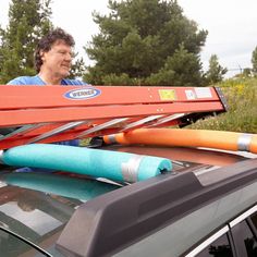 a man standing next to a car with skis on top