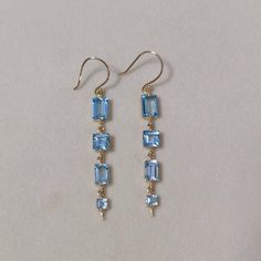 This stunning Earrings is set in 14k Solid Yellow Gold with Natural Swiss Blue Topaz  with utmost precision. It is a unique gemstone Earrings for nearly every occasion and is completely hassle-free jewelry. ITEM DETAILS: *  GEM: Swiss Blue Topaz * GEM SIZE: Baguette: 5x7 mm (LxB)                       Baguette: 4x6 mm (LxB)                       Square: 5x5 mm                       Square: 3x3 mm * Gem weight: 5.85 carats * Gold Purity: 14KT (58.33% approx.) * Gold Weight: 2.40 gram * Total Weig Vintage Blue Drop Earrings Jewelry, 14k Gold Blue Dangle Earrings, Blue 14k Gold Dangle Earrings, Blue Topaz Dangle Earrings Fine Jewelry, Nature-inspired Blue Dangle Earrings, Blue Rectangular Gemstone Earrings, Elegant Blue Diamond-cut Earrings, Elegant Blue 14k Gold-filled Earrings, Handmade Jewelry Box