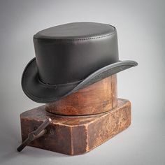 The Bromley leather top hat sports a practical streamlined brim and a low, wide, understated crown. Classic Black Hat With Flat Crown, Classic Black Hat Band With Flat Crown, Classic Adjustable Top Hat With Flat Crown, Classic Adjustable Fitted Hat With Flat Crown, Classic Black Hat With Adjustable Fit, Classic Black Adjustable Hat, Fitted Black Hat Bands, Fitted Black Leather Hat, Black Fitted Leather Hat