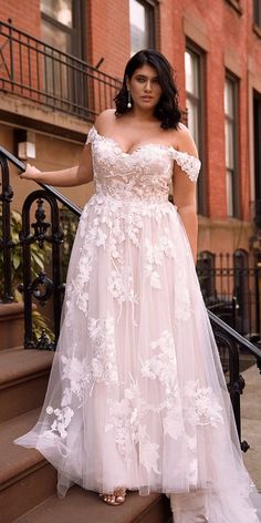 a woman in a wedding dress standing on some steps