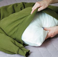 a person laying on top of a bed with a pillow in the middle of it