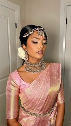 a woman wearing a pink sari and jewelry