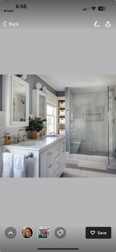 an image of a bathroom with white cabinets and marble counter tops on the phone screen