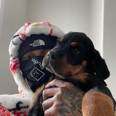 a man holding a dog wearing a face mask