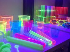 many different colored cups and glasses on a table