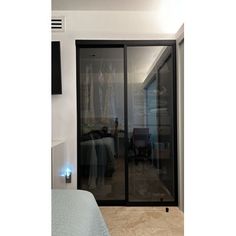 a bedroom with a bed and sliding glass doors leading to the closet area in the room