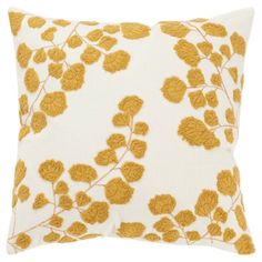 a yellow and white pillow with leaves on it