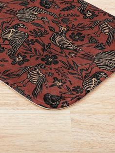 a red and black rug with birds on it