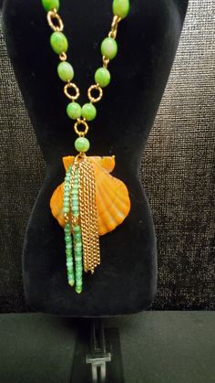 Orange Seashell, Green Beaded, Dangle Drop Chained Necklace Length: 32 inches long Weighs: 2.2 lbs. Pendants size: 55 by 54 mm Elegant Green Necklace For Beach, Long Green Necklaces For The Beach, Green Long Necklace For Beach, Elegant Long Beaded Necklace For Beach, Beach Necklaces With Round Beads Chain, Green Necklace With Adjustable Chain For Beach, Green Adjustable Chain Necklace For Beach, Beach Beaded Dangle Necklaces, Beaded Dangle Necklaces For The Beach