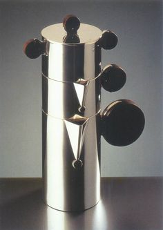 a stainless steel coffee pot with spoons in it