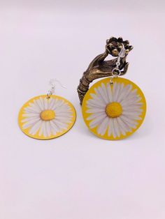 2 inch round, lightweight, fun, unique, sunny, Daisy earrings. Full design on both the front and back. All hooks are hypoallergenic and come with rubber backings to keep your earrings secure. **All items are handmade and therefore may have slight variations making them just as unique and as perfect as you are! Yellow Round Earrings For Beach, Hand Painted Yellow Earrings For Summer, Adjustable Round Fun Earrings, Handmade Yellow Circle Earrings, Adjustable Circle Earrings For Summer, Summer Adjustable Circle Earrings, Handmade Summer Flower Earrings, Hypoallergenic Round Summer Earrings, Hypoallergenic Round Earrings