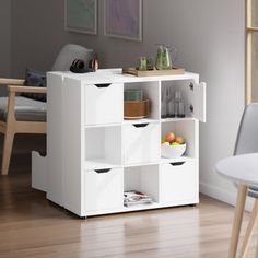 a white shelf with several compartments and plates on it next to a dining room table