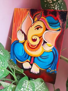 an elephant painted on the side of a wooden box next to a potted plant