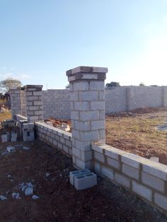 an unfinished brick wall in the middle of a yard