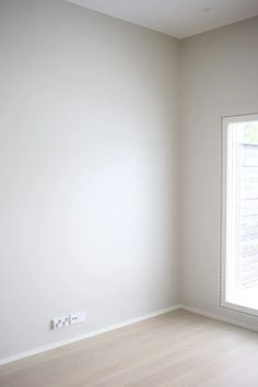 an empty room with white walls and wood floors