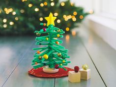 a small green christmas tree sitting on top of a wooden table