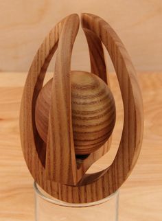 a wooden object sitting in a glass on top of a table