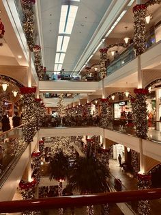 the inside of a shopping mall with christmas decorations on the balconies and lights