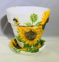 a sunflower cup and saucer with a bee on the side, sitting next to each other