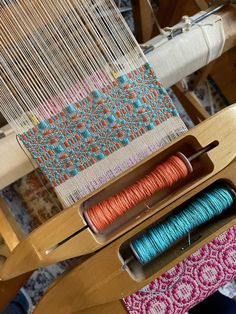 two spools of thread sitting on top of a weaving machine