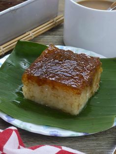 a piece of cake sitting on top of a green plate next to a cup of coffee