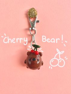 a bear keychain with a cherry on it