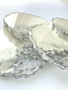 three silver plates sitting on top of a white table