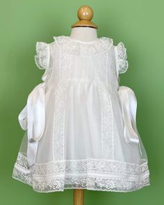 A delicate and romantic dress, made with lightweight white organza with laces. It has satin ribbons on the sides. It has buttons on the back for closure, and it comes with a matching bonnet. Made in Spain Dry clean Final sale, no exchanges nor returns are available White Christening Dress, White Baptism Dress, Baptism Dresses, Christening Dresses, Dress For Baby Girl, Organza Lace, Dress For Baby, Spanish Fashion, Baptism Dress