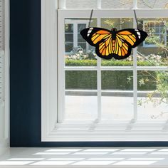 a yellow and black butterfly hanging from a window