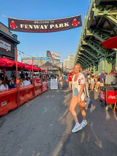 a woman is walking down the street in front of some booths