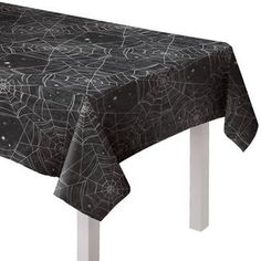 a black table cloth with spider webs and stars on it, sitting on a white metal frame