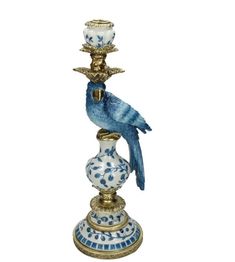 a blue and white bird sitting on top of a candle holder