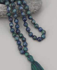 Harness the power of Azurite beads to gain clarity and personal wisdom during your meditative practice. Made of 108 beads, use a mala simply by moving through its beads one by one. Bead size: 6mm Individually Knotted between each bead Made of Azurite beads Blue/green shaded cotton tassel Bead Configuration: 108 Azurite beads + 1 Guru Bead Due to the nature of natural stones, this piece will feature exquisite variations in surface patterns and overall appearance. Such details enhance the unique b Blue Round Beads Mala For Meditation, Blue 8mm Beads Spiritual Mala, Blue Mala With 8mm Beads For Meditation, Blue Spiritual Mala With 8mm Beads, Spiritual Blue Mala With 108 Beads, Buddha Groove, Surface Patterns, Mala Meditation, 108 Bead