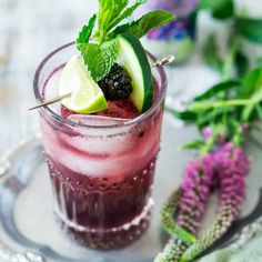 an alcoholic drink with lime, blackberry and mint