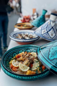 a table topped with plates and bowls filled with food