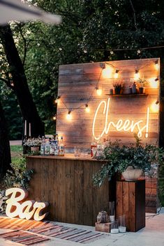 an outdoor bar is decorated with lights and greenery